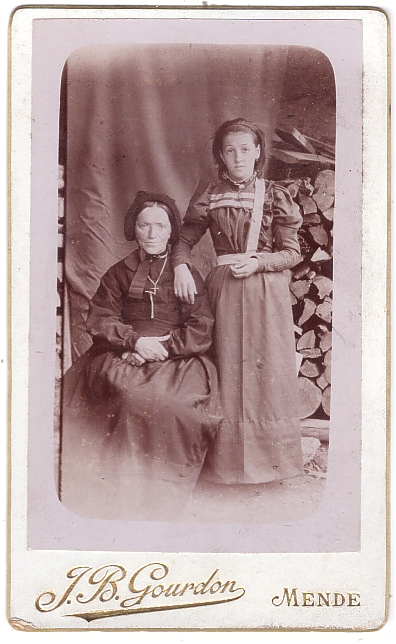 Deux femmes posant en extérieur devant un tas de bois