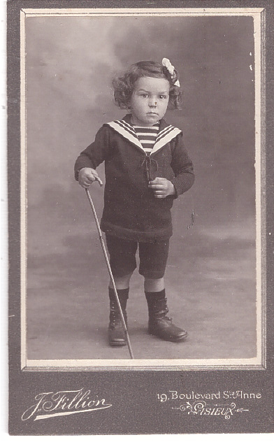 Enfant vêtu d'une marinière tenant une canne