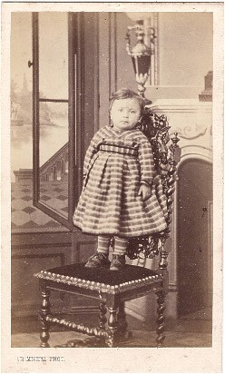 Enfant posant debout sur une chaise