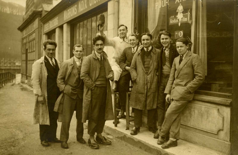 Henri Béroul (en blouse blanche) pose devant l'atelier où il est apprenti