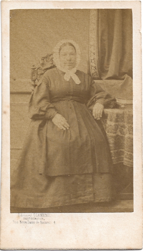 Femme assise coiffée d'un bonnet blanc