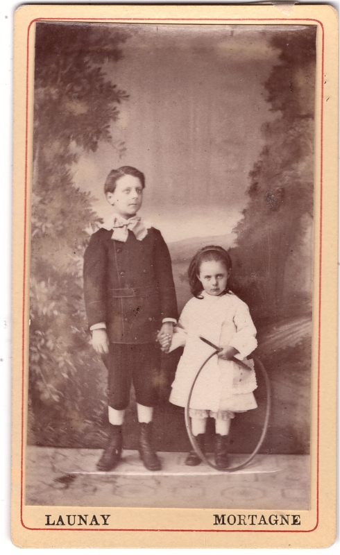 Garçon posant avec sa petite soeur qui tient un cerceau