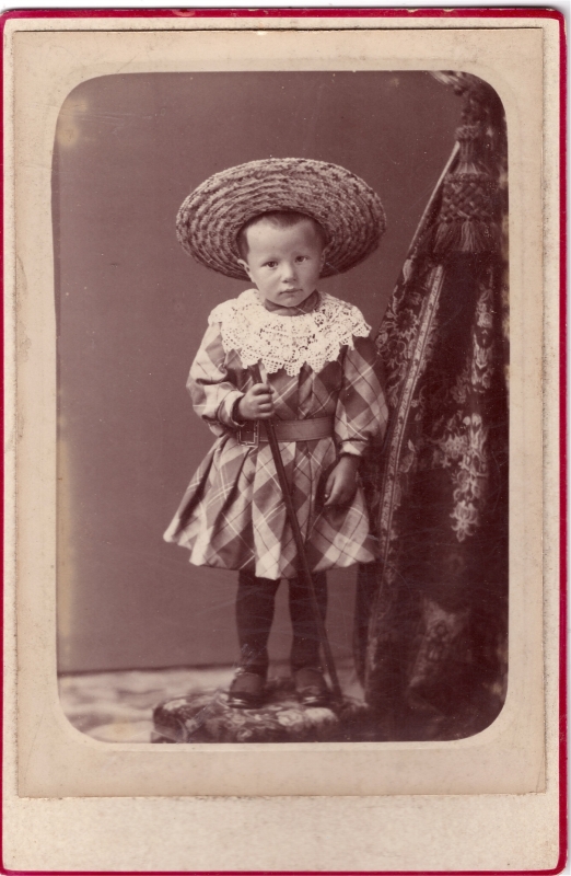 Enfant portant une robe d'arlequin et un grand chapeau de paille