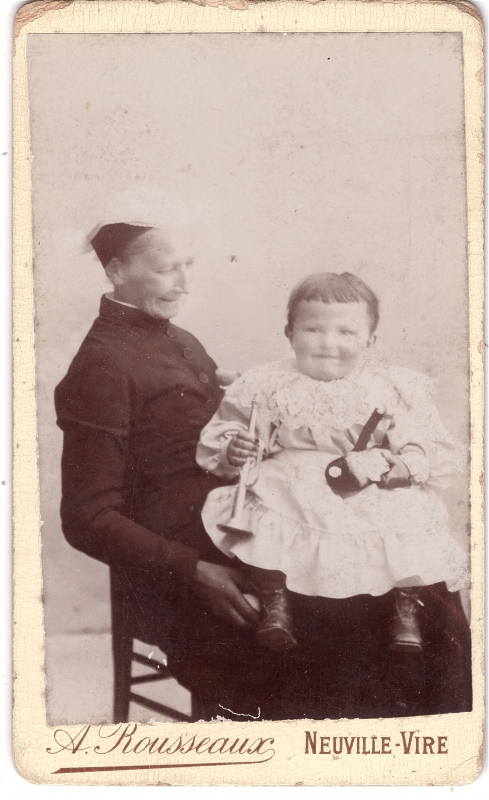 Bambin, des jouets dans la main, assis sur les genoux de sa grand-mère 
