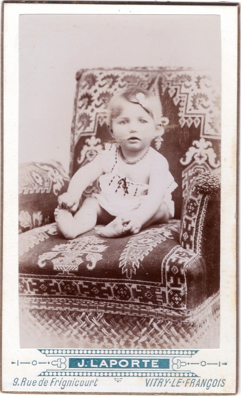 Bambin blond assis sur un fauteuil