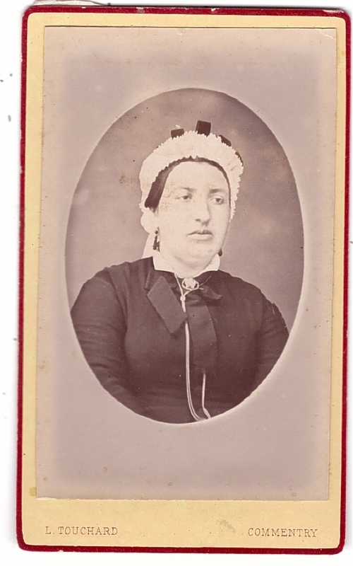 Femme portant une coiffe  blanche avec des rubans noirs