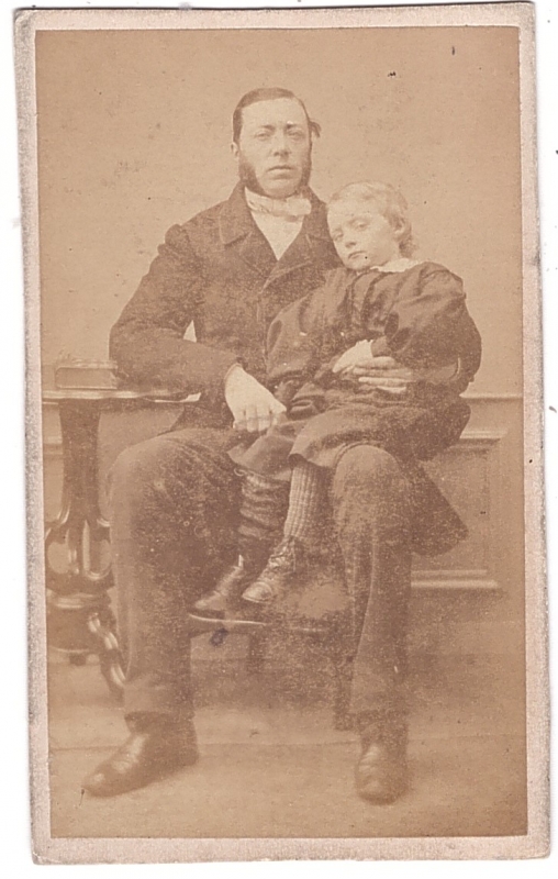 Homme assis tenant dans son bras un enfant