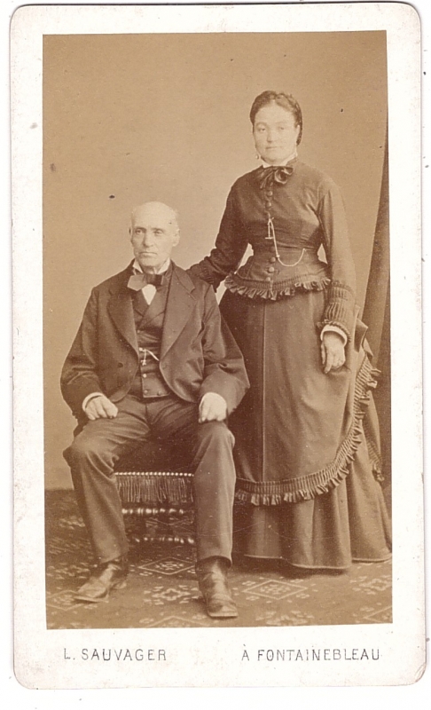 Femme posant debout près de son mari assis