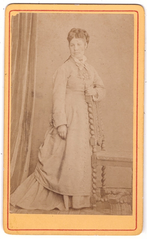 Femme posant debout  près d'une chaise