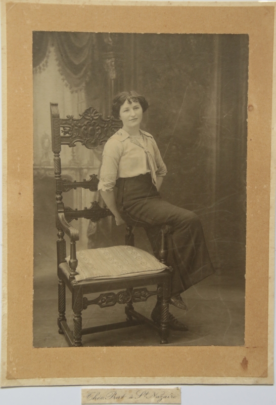 Jeune femme assise sur l'accoudoir d'un fauteuil