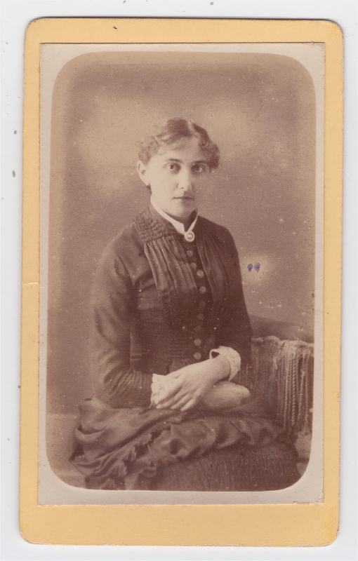 Jeune femme portant un camée sur une robe à gros boutons