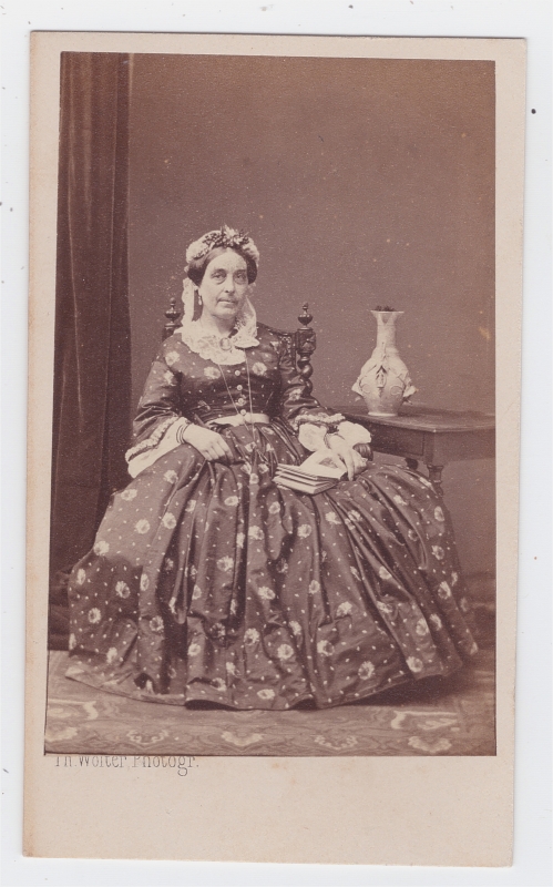 Femme assise, un livre ouvert posé sur sa belle robe