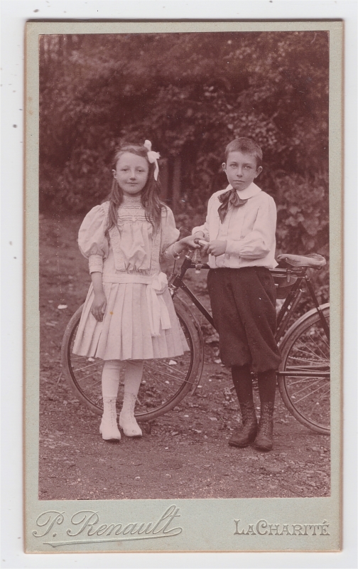 Garçont tenant sa bicyclette, posant avec sa soeur (?)
