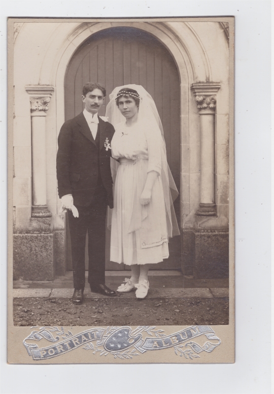 Mariés posant devant une église