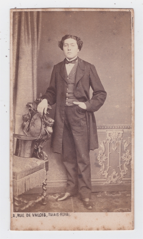 Homme jeune posant debout, une main dans sa poche gousset