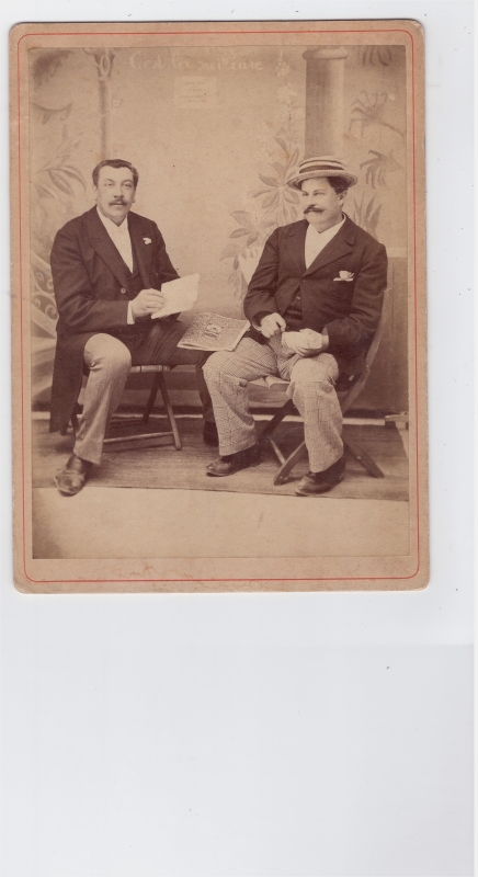 Deux hommes assis dont l'un porte un canotier