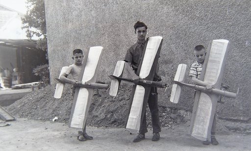 Trois garçons posant chacun avec une maquette d'avion