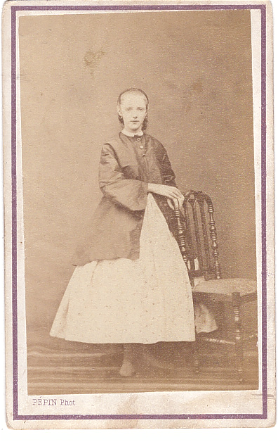 Jeune fille en jupe blanche debout près d'une chaise