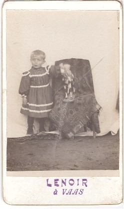Enfant posant à côté de son jouet