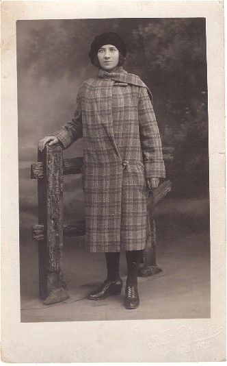 Femme posant en manteau près d'une barrière factice