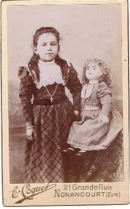 Petite fille posant avec sa grande poupée