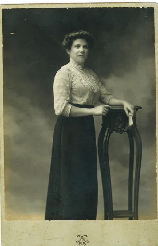 Femme posant  de bout à côté d'une sellette;