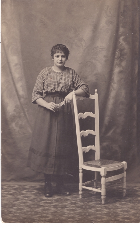 Jeune femme debout près d'une chaise à haut dossier