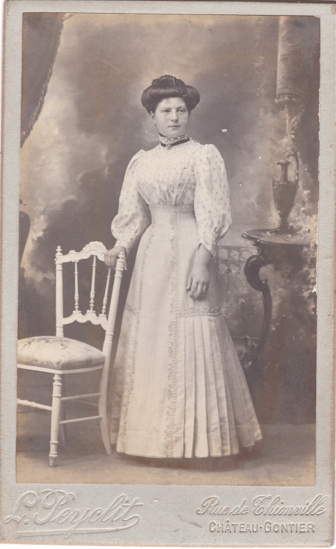 Jeune femme en robe blanche debout près d'une chaise