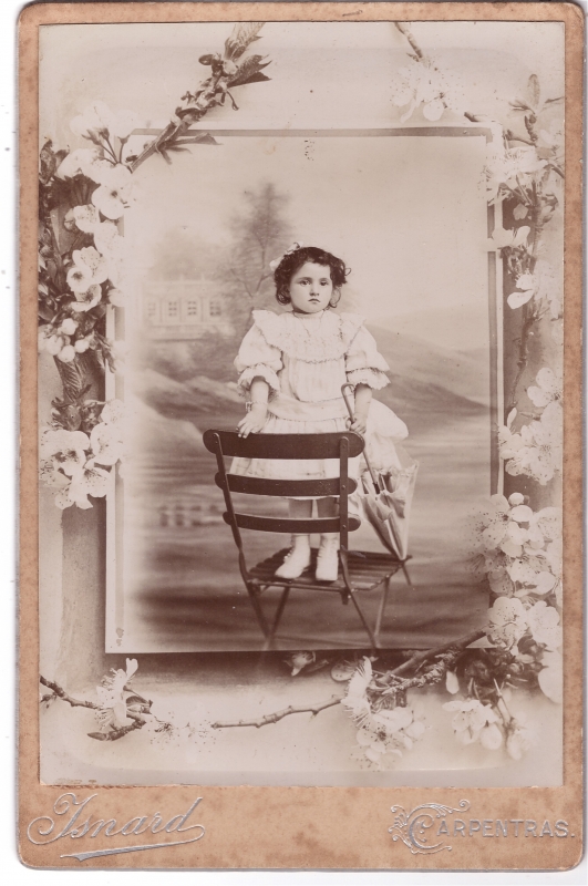 Fillette posant debout sur une chaise de jardin