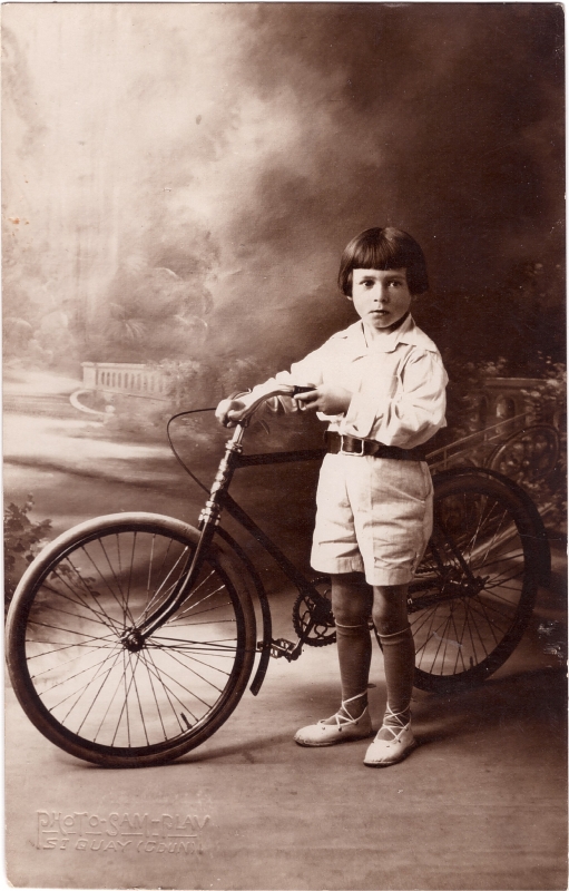 Garçonnet posant en atelier tenant sa bicyclette