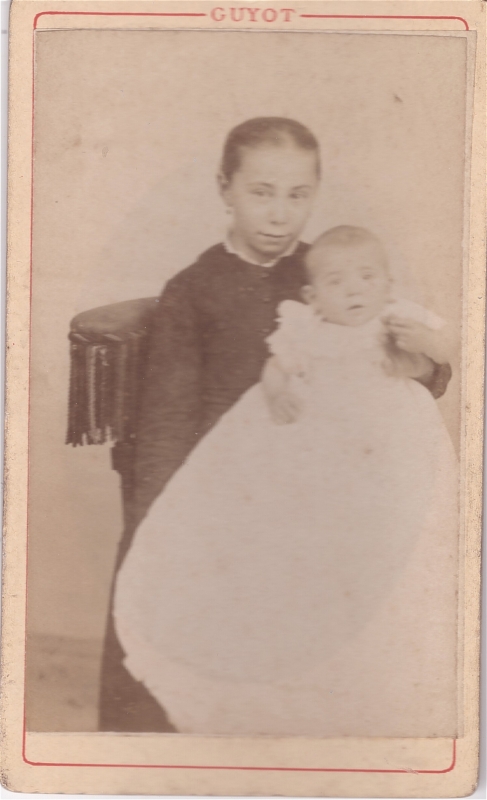 Jeune femme tenant un bébé dans sa robe de baptême (?)