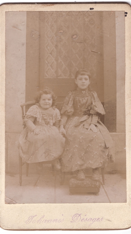 Deux  soeurs assises devant une porte