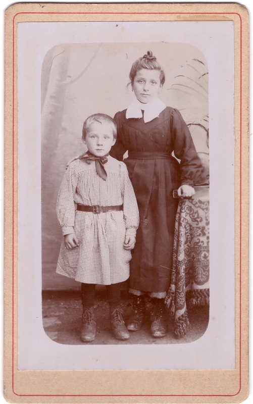 Enfant en blouse posant à côté de sa grande soeur (?)