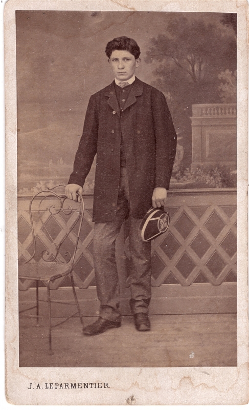 Jeune homme nommé Eugène Brocard tenant une casquette d'uniforme