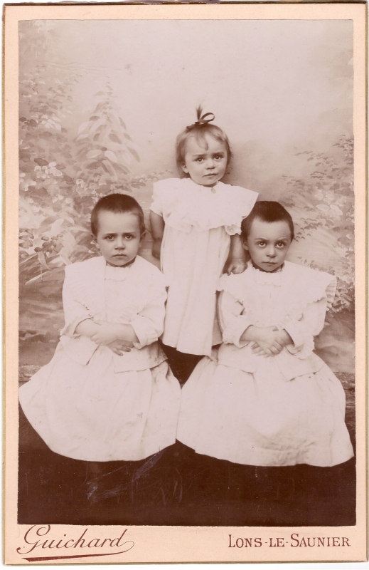 Trois enfants en robe blanche
