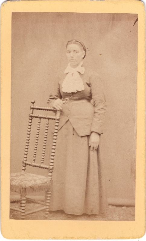 Femme debout près d'une chaise à haut dossier