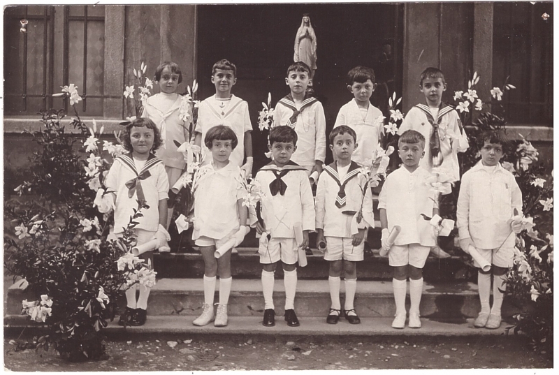 Groupe d'enfants vêtus de blancs tenant une fleur (Première communion ?)