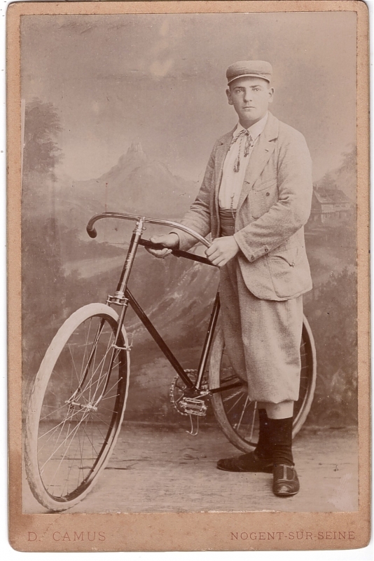 Jeune homme posant en atelier avec sa bicylette