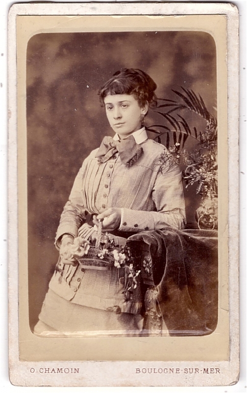Jeune femme, prénommée Clara, tenant un panier fleuri
