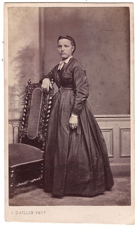Femme posant debout près d'une chaise