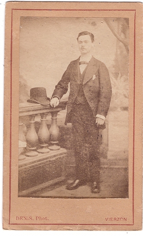 Homme debout, son chapeau posé sur une balustrade