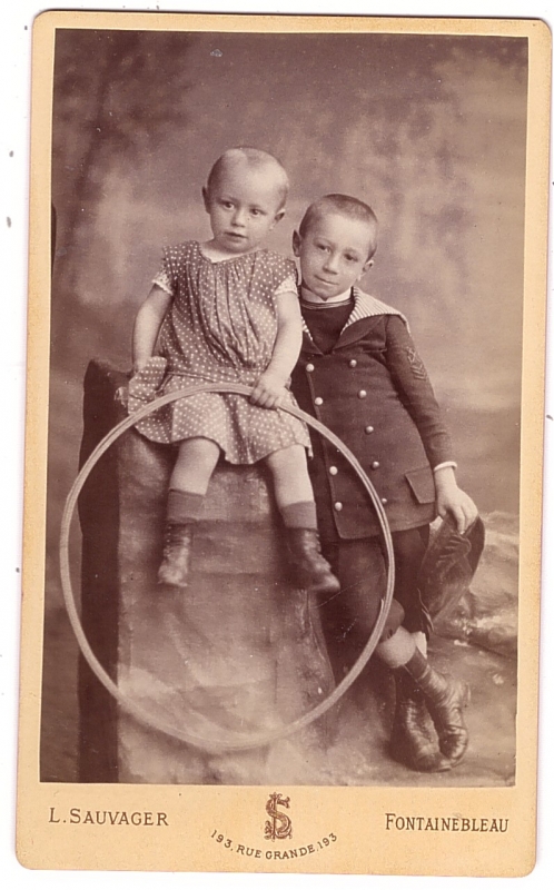 Deux enfants, le plus jeune tenant un cerceau