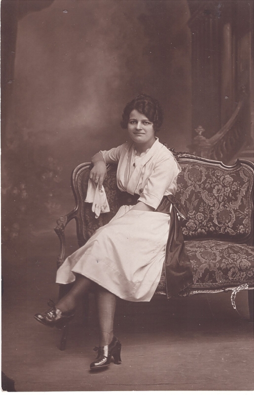 Jeune femme en robe blanche assise sur un canapé