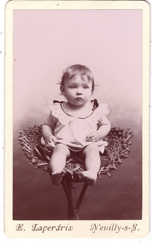 Bambin posé sur un siège en vannerie