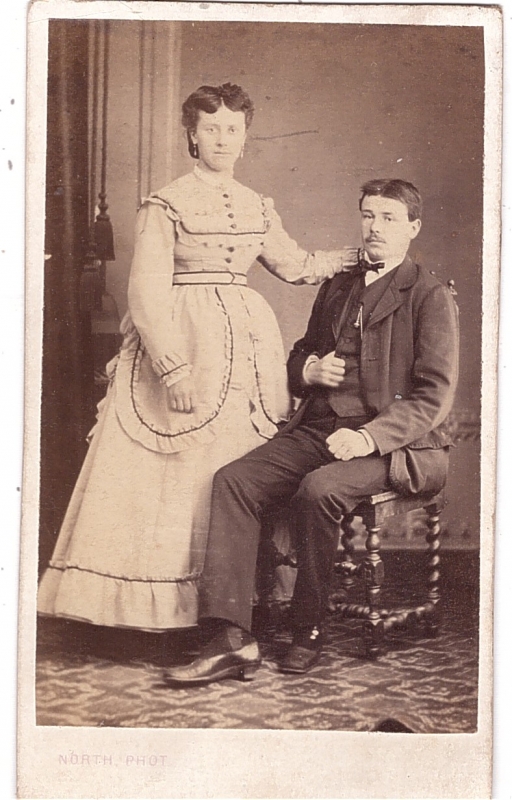 Femme debout près de son mari assis