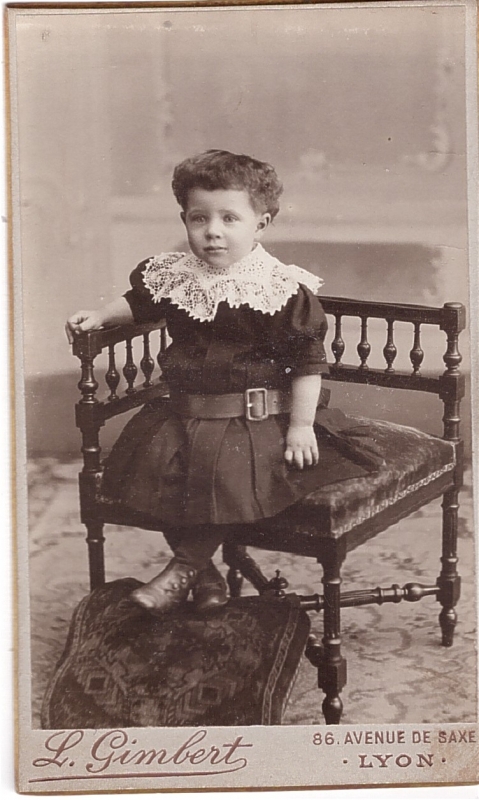 Enfant les épaules couvertes d'un grand col de dentelle sur sa robe ceinturée 