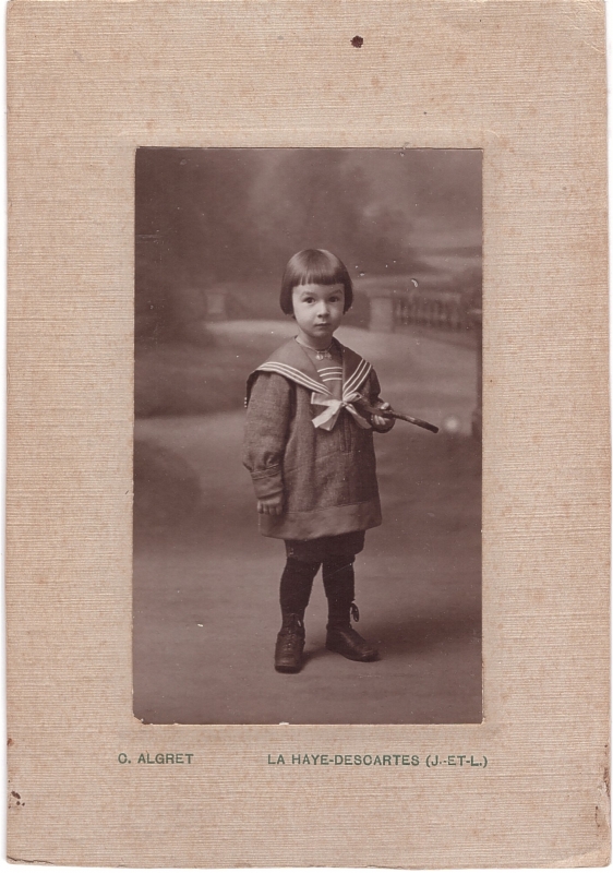 Enfant vêtu d'une vareuse de marin qui tient une pipe dans sa main