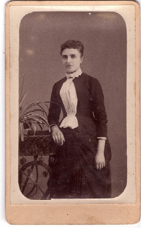 Jeune femme avec un jabot blanc qui tranche sur sa robe noire