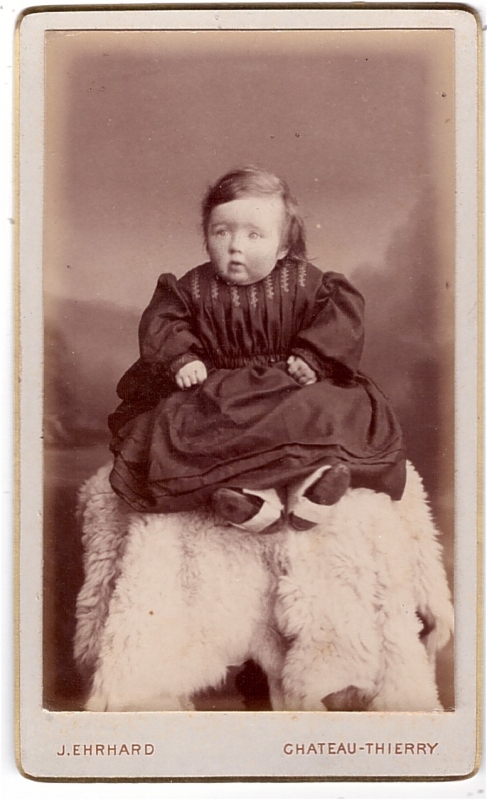Bambin assis sur une peau de mouton