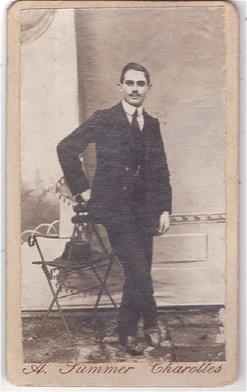 Homme posant debout à côté d'une chaise de jardin
